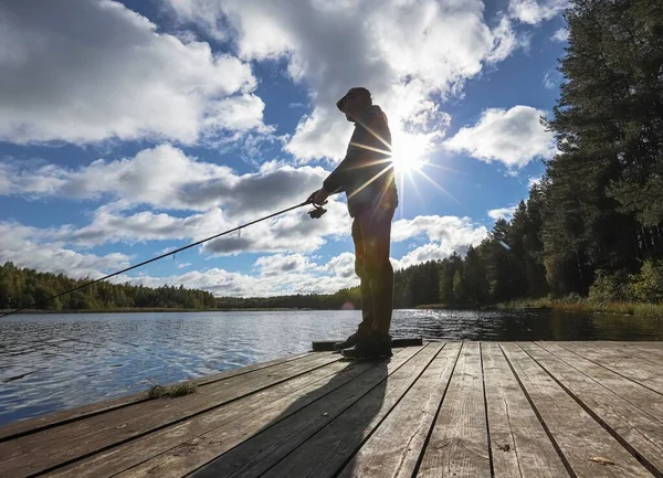 Pescatore pesca da solo con canna e sole — Foto Stock