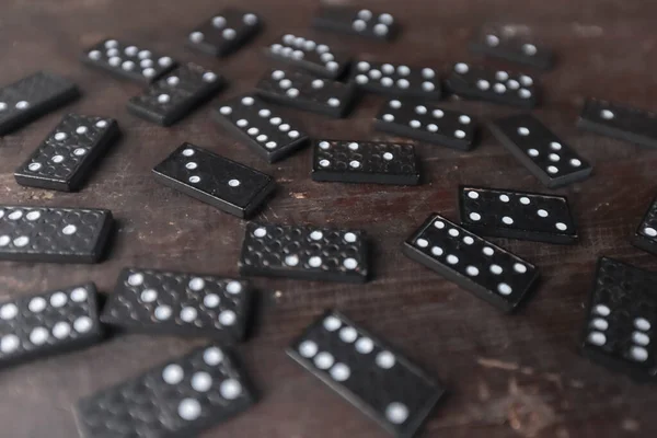 Domino spelpjäser utspridda på gamla trä skrivbord, selektiv fokus och perspektiv — Stockfoto