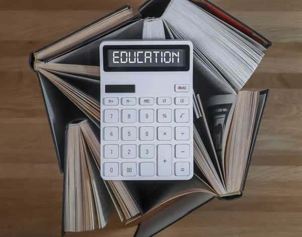 Concepto de educación financiera. Palabra sobre calculadora con libros sobre contabilidad y finanzas —  Fotos de Stock