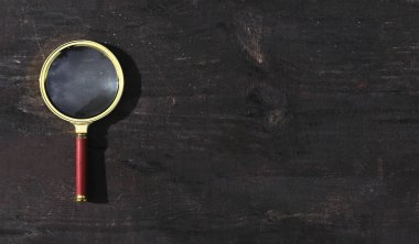 Ahşap arka planda büyüteç ve fotokopi alanı. Metin için pankart yeri