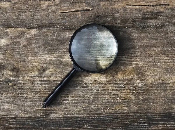 Magnifying lens on wood aged rustic background — Stock Photo, Image