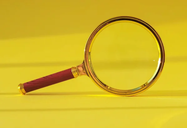 Magnifying glass on yellow background with light and shadow — Stock Photo, Image