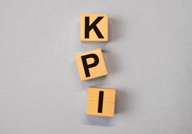 KPI kısaltması. Arkaplandaki tahta küplerde anahtar performans göstergesi