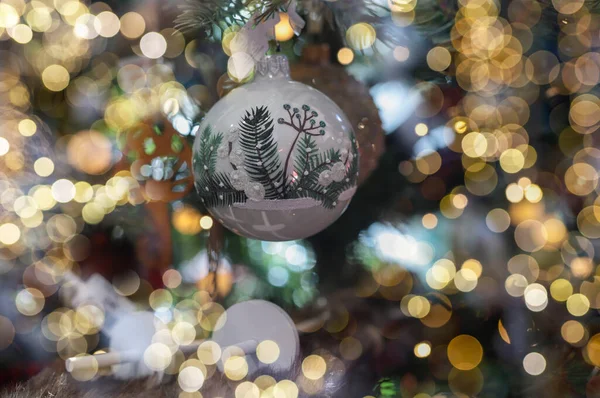 Minsk, Belarus - October 18 2021 Christmas bauble with blurred garland lights around — Stock Photo, Image