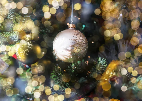 Golden bauble, Christmas ornament with blurred magic garland lights — Stock Photo, Image