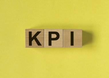 KPI kısaltması. Sarı arkaplandaki tahta küplerde anahtar performans göstergesi