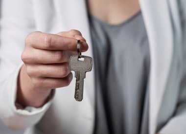 Anahtar yüzüğünün anahtarları bu bayanın elinde, yakın plan. Ev sahibi kapı anahtarı veriyor.