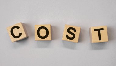 Kelimeye mal oldu. Gri arkaplandaki tahta küplere harfler