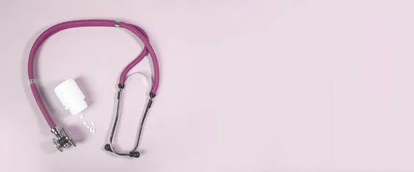 Rózsaszín sztetoszkóp és tabletták a nők egészségére. Orvosi banner háttérrel másolás helyet szöveg — Stock Fotó