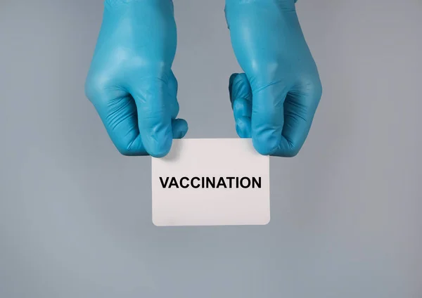 Vaccinationsord på papper i handen i handsken — Stockfoto