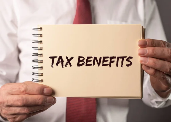 Tax benefits word on paper in businessman hands — Stock Photo, Image