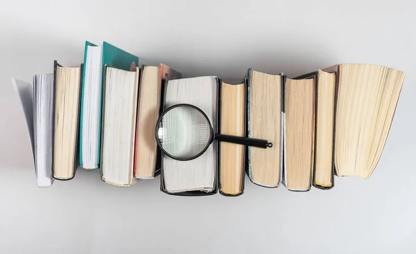 Magnifying lens over books row. Concept of knowledge and studying — 图库照片