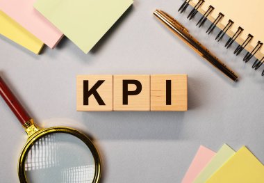 KPI kısaltması. Arkaplandaki tahta küplerde anahtar performans göstergesi