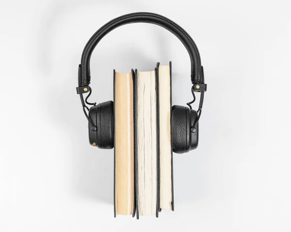 Koncept audio knih. Klasický zásobník papírové literatury se sluchátky, pohled shora. Audiobook poslech a čtení koncepce — Stock fotografie