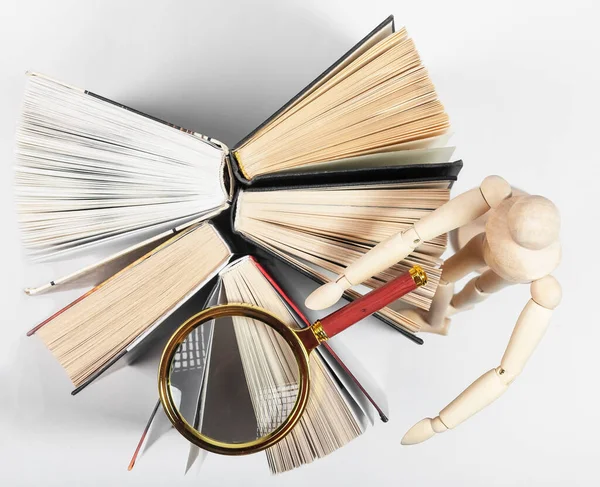 Magnifier, wood person reading and studying books. Concept of knowledge, research — Stock Photo, Image