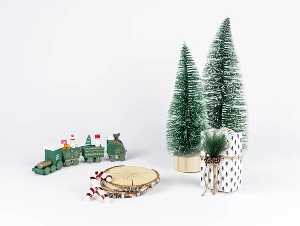 Pedestal de producto, podio de madera para la presentación de regalos de Navidad. Plataforma con abetos, bastones de caramelo, juguete de tren y regalo de Navidad —  Fotos de Stock