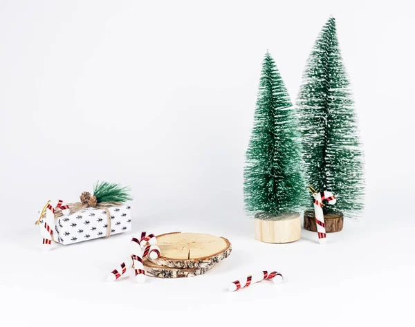 Pedestal de producto, podio de madera para la presentación de regalos de Navidad. Plataforma con abetos, bastones de caramelo y regalo de Navidad —  Fotos de Stock
