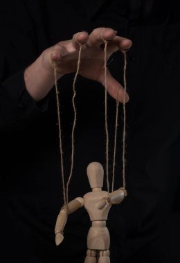 Boss hand manipulating and controling wood marionette. Master of puppet concept
