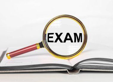Exam word. Examination concept through magnifying glass