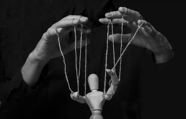 Hands manipulating puppet. Master of marionette in action