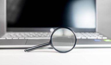 Laptop büyüteçle. İnternet arama ve SEO araştırma konsepti