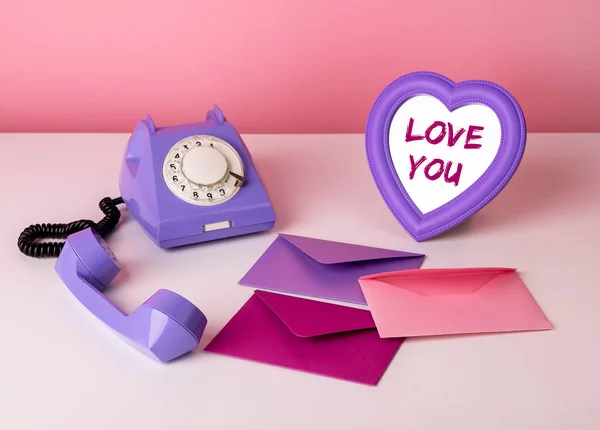 Trendy Valentijnsdag samenstelling van schattige roze en violette objecten. Retro telefoon, liefdesenveloppe en hartvormige spiegel met Love you words — Stockfoto