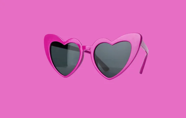 Hjärtformade solglasögon på rosa bakgrund. Alla hjärtans dag solglasögon — Stockfoto