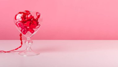 Sevgililer Günü konsepti. Pembe arka planda kalpler kurdelesi olan afiş. Kopya alanı ile soyut romantik kompozisyon. 