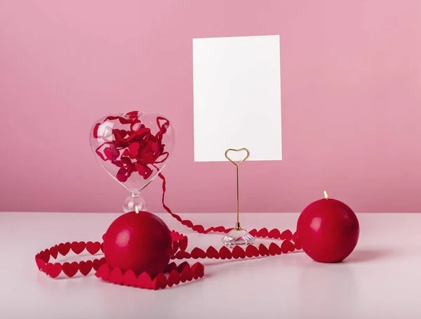 Valentin napi képeslap. Szívszalagok és gyertyák az asztalnál rózsaszín alapon. Csendélet szerelemben és romantikus stílusban. Mockup — Stock Fotó