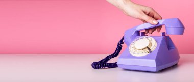 Pembe arka planda retro telefonu tutan kadın. Metin için kopyalama alanı olan pankart