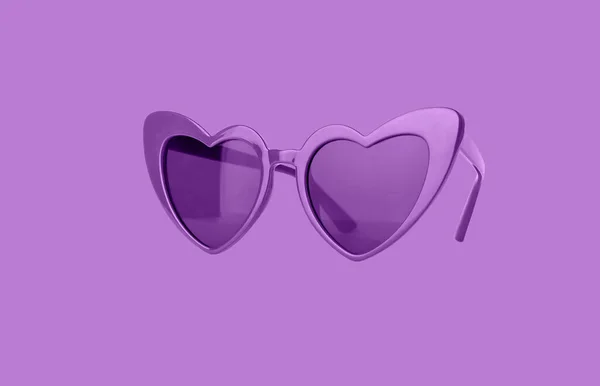 Gafas de sol de corazón púrpura brillante sobre fondo violeta. Accesorio de mujer para vacaciones de verano. —  Fotos de Stock
