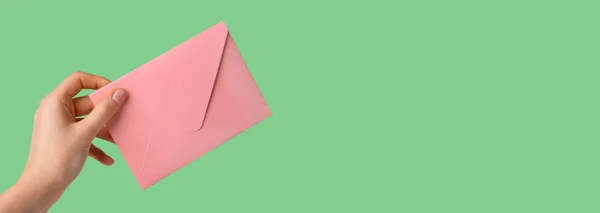 Hand hält Umschlag, sendet rosa Post. Frühlingsbanner mit Kopierraum für Text — Stockfoto