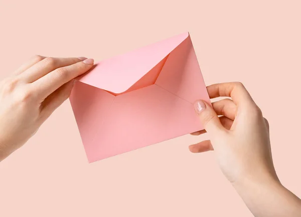 Frauenhände mit rosa Umschlag — Stockfoto