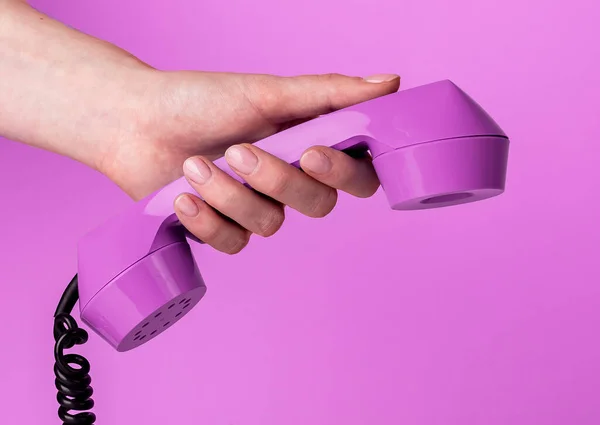 Hand hält Retro-Telefonhörer auf trendigem Hintergrund — Stockfoto
