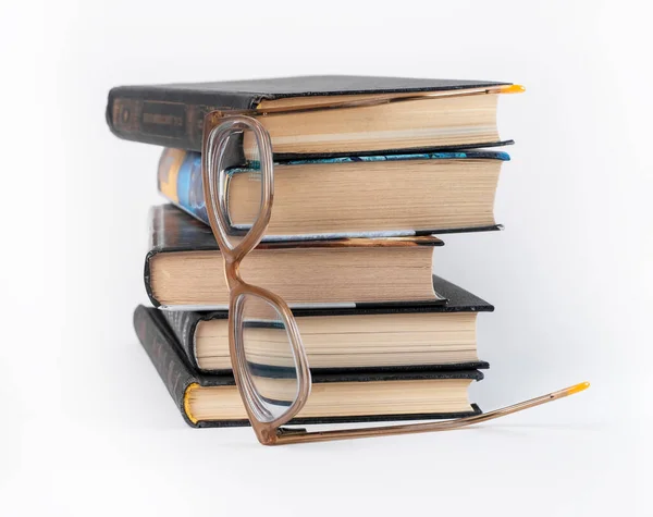 Böcker staplas med glasögon. Utbildning, läsfritid, datasökning, kunskapskoncept. — Stockfoto