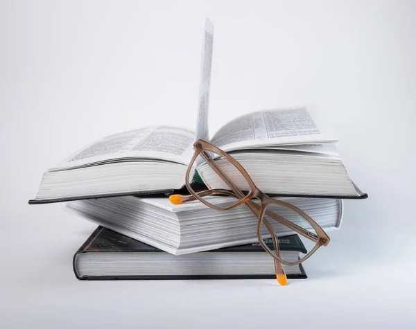 Böcker staplas med glasögon. Utbildningskoncept Läsa, förbereda sig för tentor, bedriva forskning. — Stockfoto