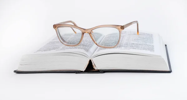 打开书本时的眼镜。教育概念。圣经，字典阅读. — 图库照片