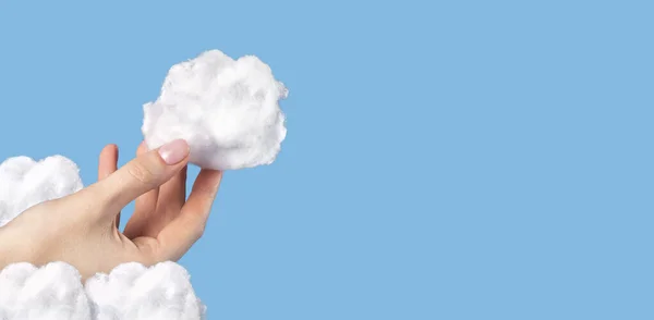 Banner med handen håller bomull moln på blå himmel bakgrund. Molnigt väder- och meteorologikoncept. Surrealistiskt sätt. Upphovsrätt. — Stockfoto