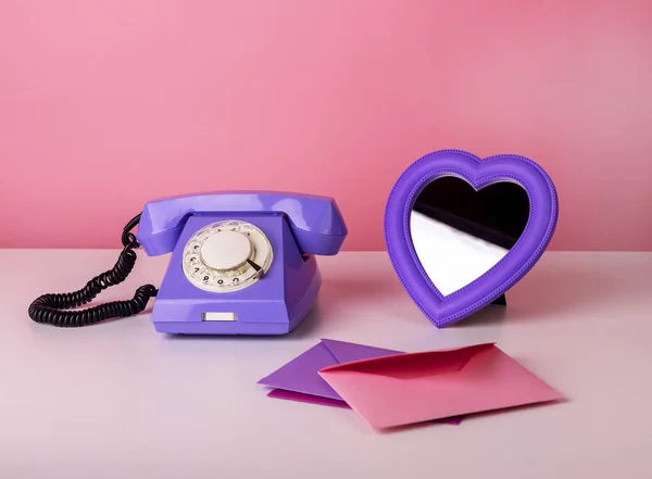 Retro telefoon op tafel met hartvormige spiegel en enveloppen. Valentijnsdag en liefde concept — Stockfoto
