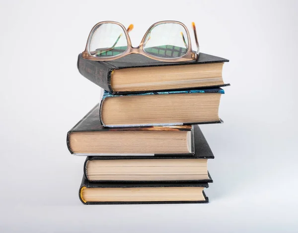 Brýle na hromadě knih. Vzdělávání a čtení. Hromada románů — Stock fotografie