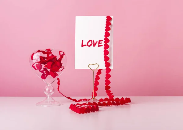 Liefde en Valentijnsdag concept. Kaart met woord en hart op roze achtergrond — Stockfoto
