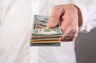Amerikan dolarları işadamının elinde. Yatırım ve mali kazanç kavramı 
