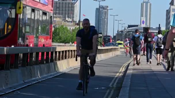 İnsanlar Waterloo Köprüsü 'ndeki bisiklet yolunda kameraya doğru bisiklet sürüyorlar. — Stok video