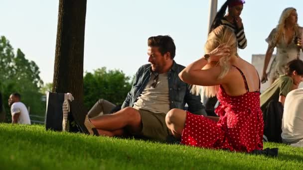 "Ένα ζευγάρι κάθισε στο γρασίδι το βράδυ τον ήλιο απολαμβάνοντας ποτά και κουβέντα στο Jubilee Gardens στη Νότια όχθη — Αρχείο Βίντεο