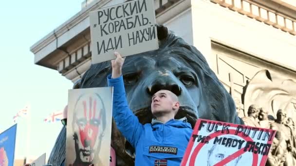 2022年2月27日 抗议者在特拉法加广场狮子雕像前高举反普京标语 — 图库视频影像