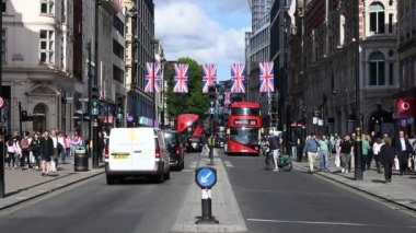 LONDON - 16 Mayıs 2022: Oxford Caddesi, Union Jack bayrağıyla süslenmiş, çift katlı otobüsler ve taksiler geçiyordu.