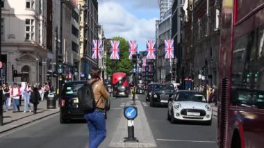 LONDON - 16 Mayıs 2022: Oxford Caddesi, Union Jack bayrağıyla süslenmiş, çift katlı otobüsler ve taksiler geçiyordu.