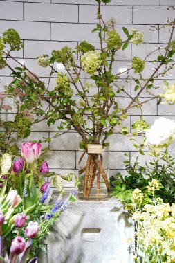 Çiçek ve yapraklardan oluşan yaratıcı bir düzen. Doğa konsepti. Çiçekli tebrik kartı. Metin alanı olan renkli bahar çiçekleri. Doğal trend dekoratif tasarımı.