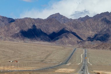 Çin 'in Qinghai eyaletinde dağlar ve otlaklar karayoluyla uzanır.