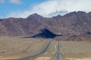 Çin 'in Qinghai eyaletinde dağlar ve otlaklar karayoluyla uzanır.